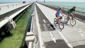MIKE HENTZ/Contributed Two bicyclists ride across the Lower Sugarloaf Channel Bridge. Many of the Florida Keys bridges need structural work to complete the Florida Keys Overseas Heritage Trail.